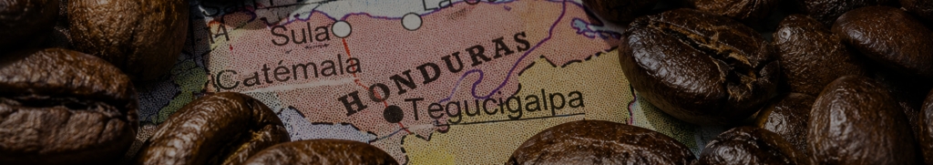 photograph of premium roasted coffee beans scattered across a vintage map, with the country name 'Honduras' partially revealed beneath the bean